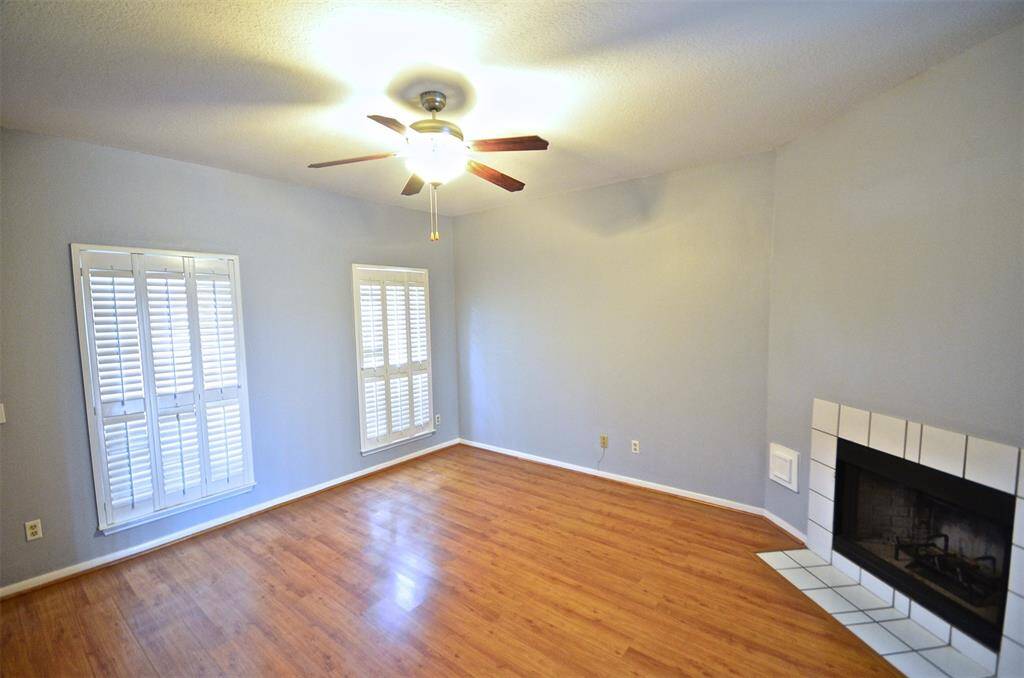 Fireplace, pretty plantation shutters, ceiling fan in living room on 1st floor.