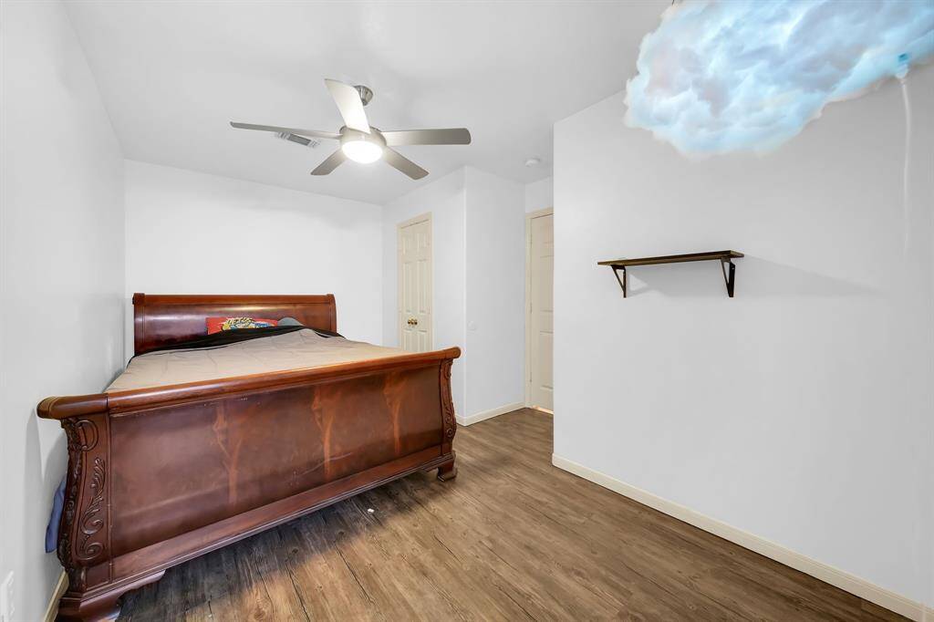 Spacious third bedroom with ceiling fan.