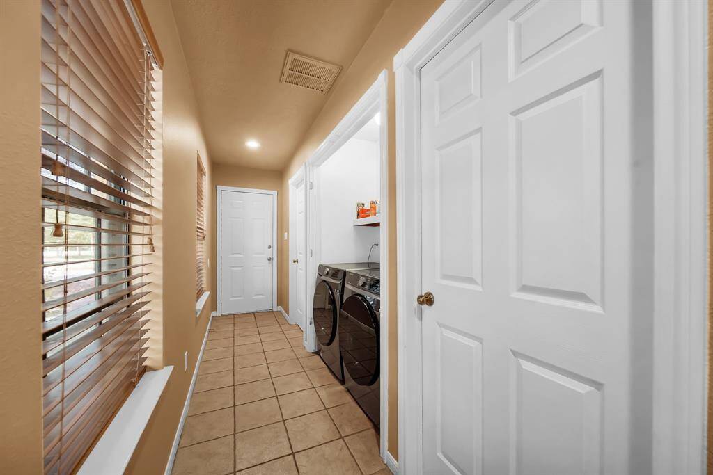 Laundry room and hall to additional living spaces in garage conversion.