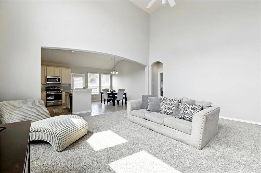 Spacious family room seamlessly connects to the kitchen and breakfast area, perfect for modern living.