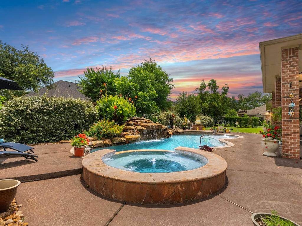 Backyard retreat with lush landscaping and sparkling pool and spa.