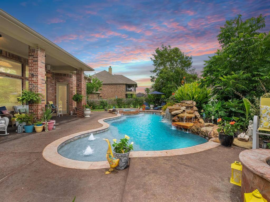 Backyard oasis with tropical landscaping and privacy fence.