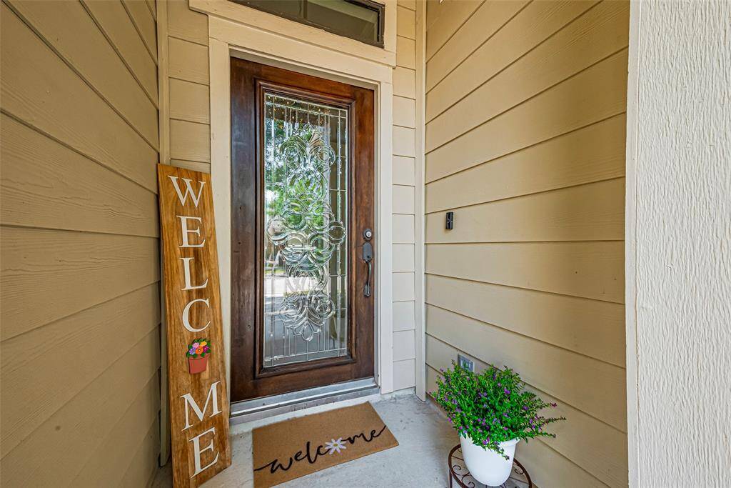 Beautifully crafted hardwood front door with covered patio.
