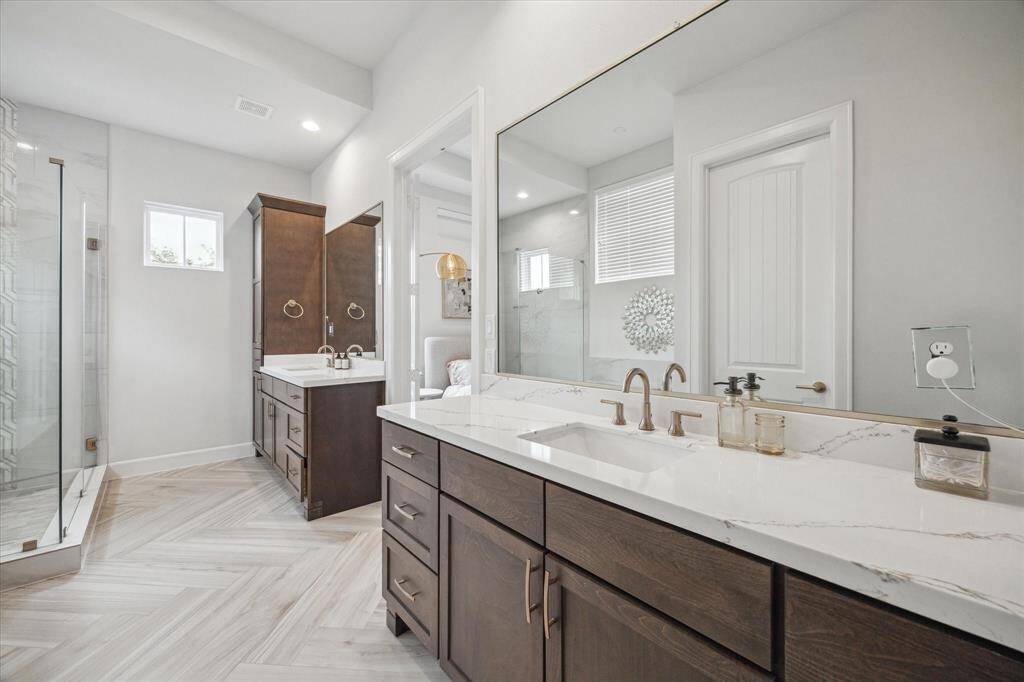 Primary ensuite has double vanities with elevated hardware and quartzite countertops