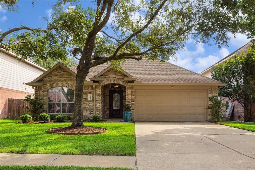 Welcome to your future home! This lovely brick exterior is framed by a majestic oak tree and lush landscaping, creating the perfect first impression. That inviting arched entryway and stylish mahogany front door say, “Come on in and stay a while."