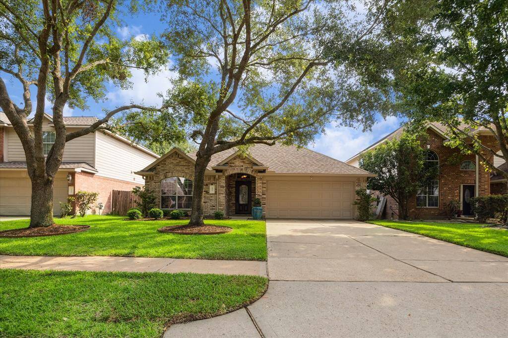 Here’s the big picture! A generous driveway leads to your spacious two-car garage, while mature trees offer both curb appeal and shade. This peaceful, tree-lined street feels like home from the moment you arrive.