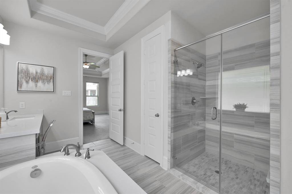 Primary bathroom features two sinks, a vanity area, soaking tub, and a walk-in Texas-sized shower with built-in bench.  Don't miss the LARGE primary closet that has a pass through to the utility room!