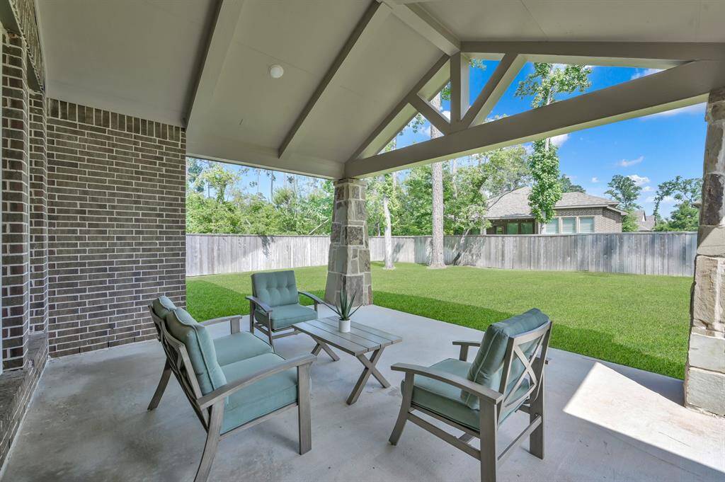 The extended covered patio, with stone columns, provides the perfect setting to enjoy the oversized lot.
