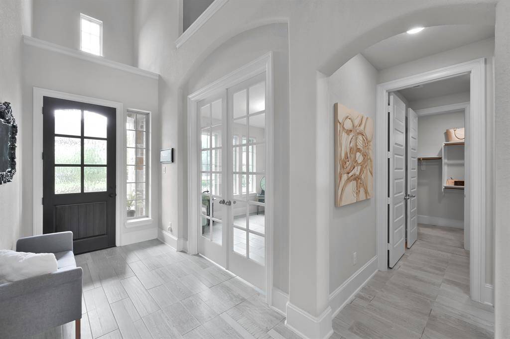 Designated office conveniently located at the front of the home features French doors.