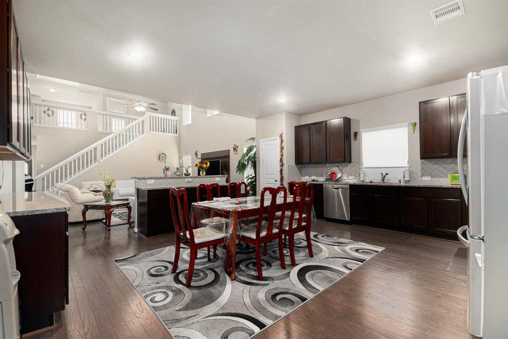 Elegant dining area with rich wood floors, modern cabinetry, and abundant natural light—perfect for entertaining and family gatherings.