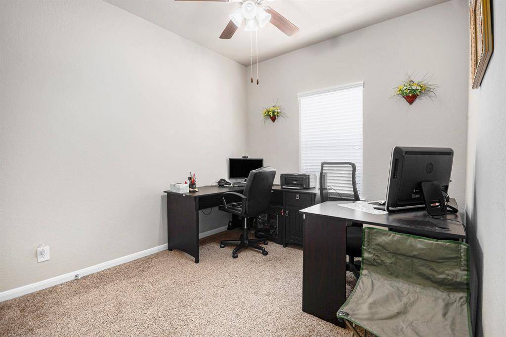 This bright and functional home office features ample space, modern decor, and a large window for natural light—ideal for productivity and focus.