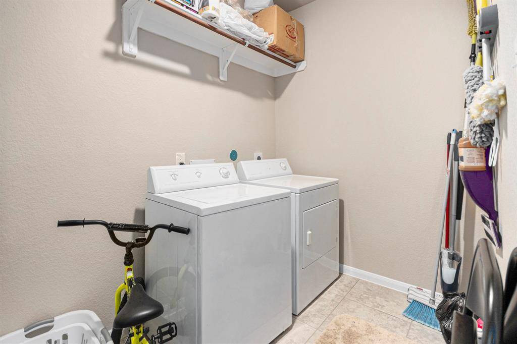 Efficient utility room with washer and dryer, ample storage, and space for all your cleaning essentials.