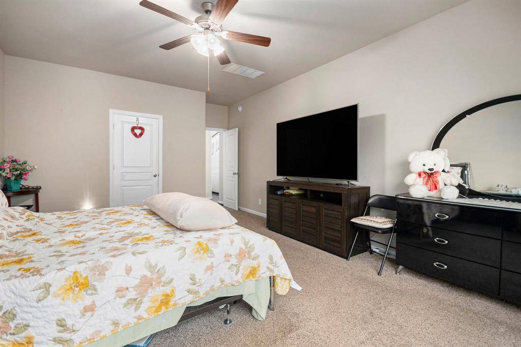 Spacious primary bedroom with attached ensuite, featuring a cozy ambiance and modern amenities for ultimate comfort.