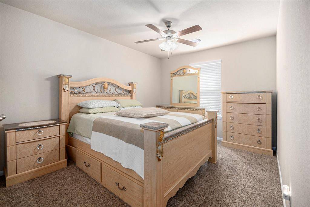 This inviting bedroom features elegant furniture, plush carpeting, and ample natural light, creating a cozy retreat.