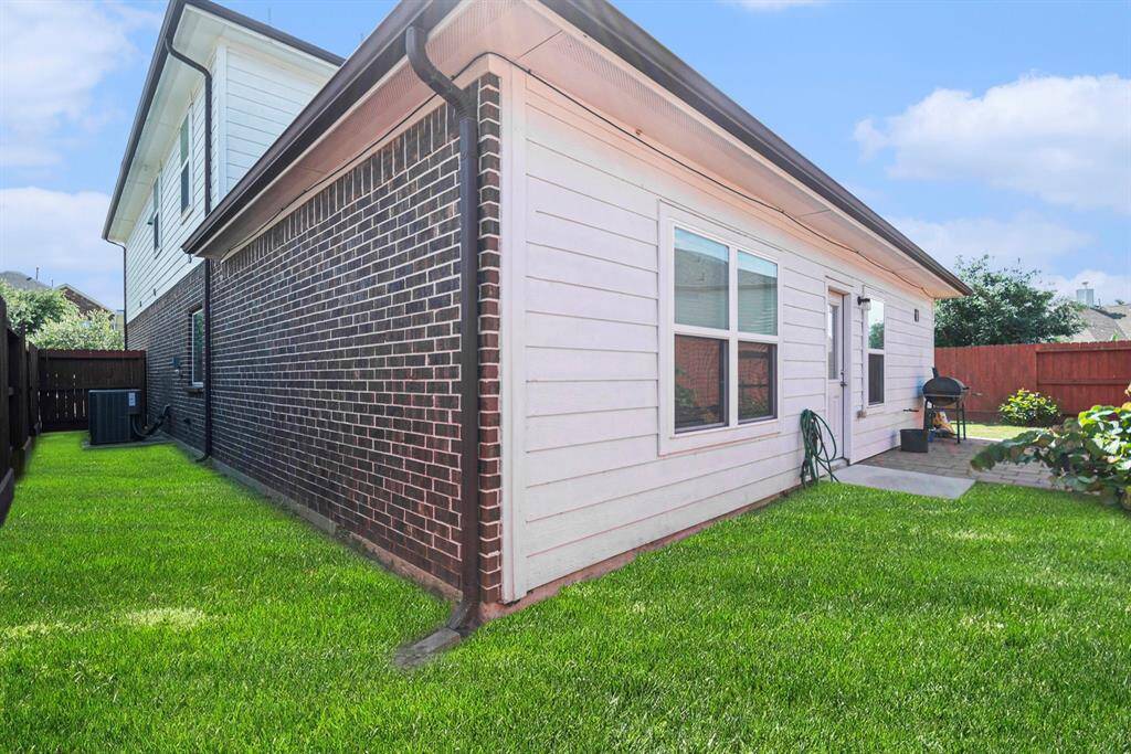 Inviting side view of the home featuring a well-maintained lawn and a cozy patio, perfect for outdoor relaxation.