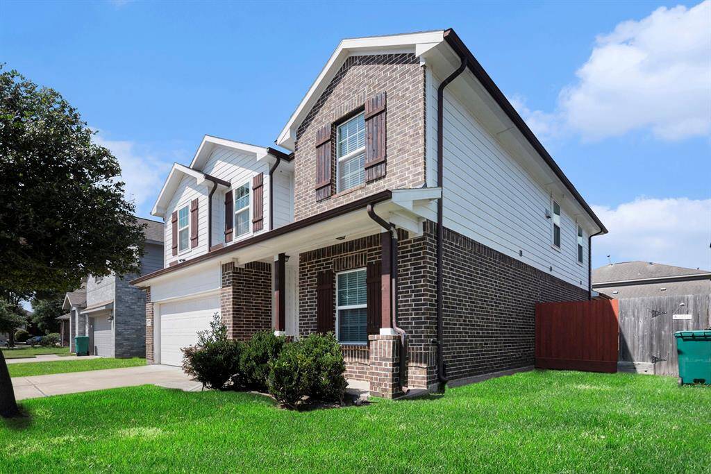 Charming two-story brick home with inviting curb appeal and a well-maintained lawn.