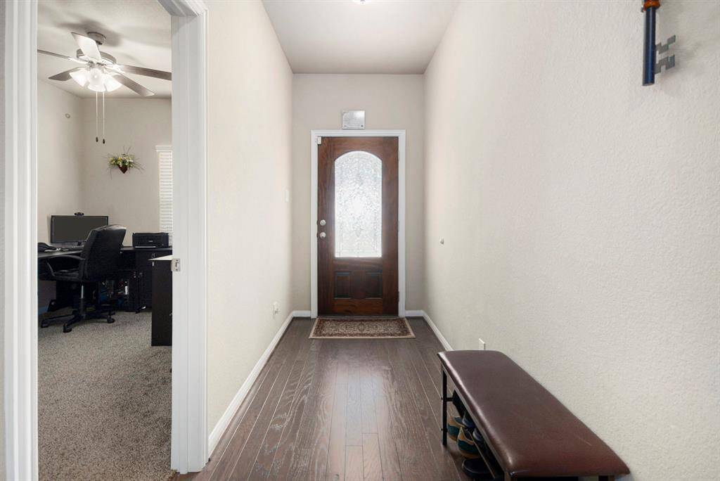 Welcome home to a bright and inviting entryway featuring elegant hardwood floors and a charming glass-paneled front door.