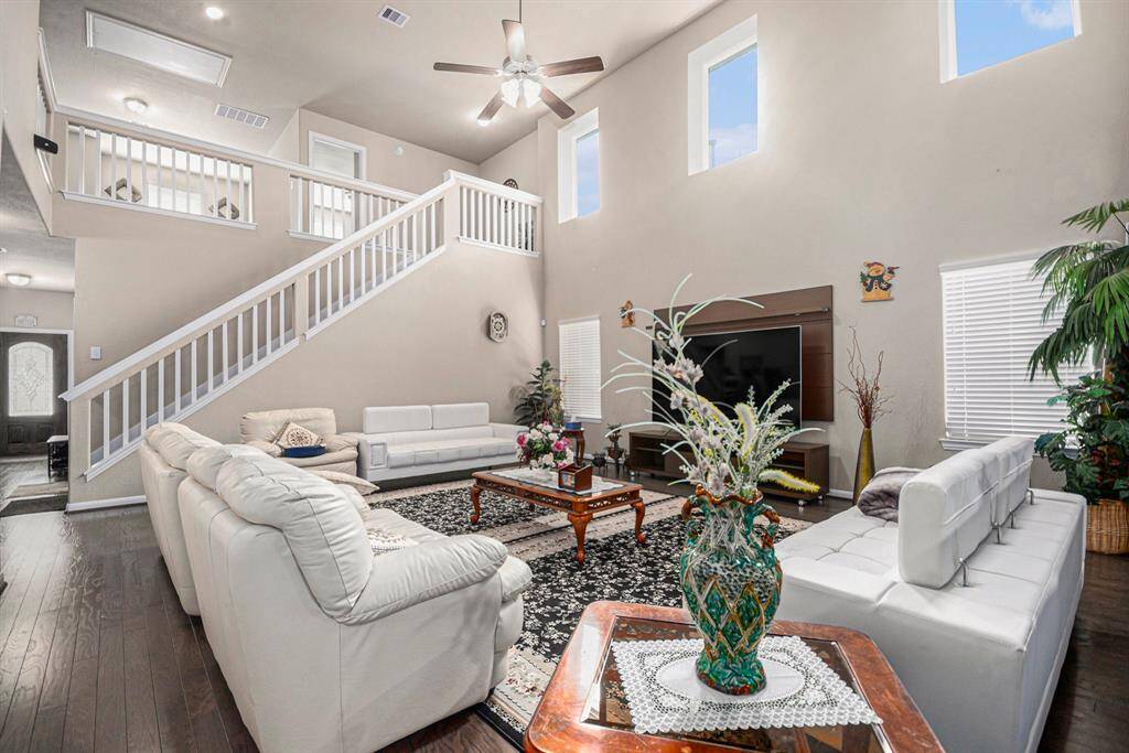 Spacious and inviting living room featuring high ceilings, abundant natural light, and elegant finishes—perfect for relaxation and entertaining.