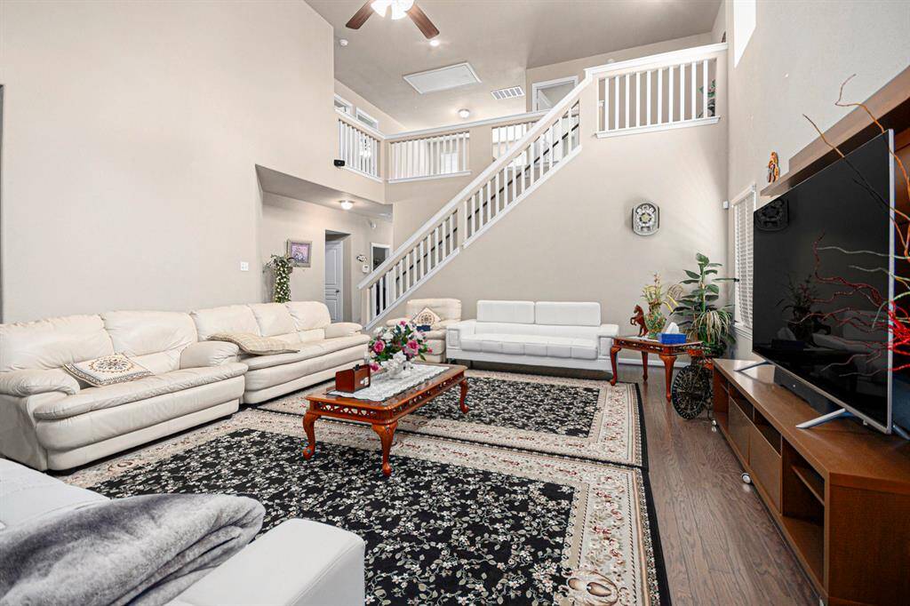 Spacious and inviting living room with high ceilings, elegant decor, and abundant natural light. Perfect for relaxing or entertaining.