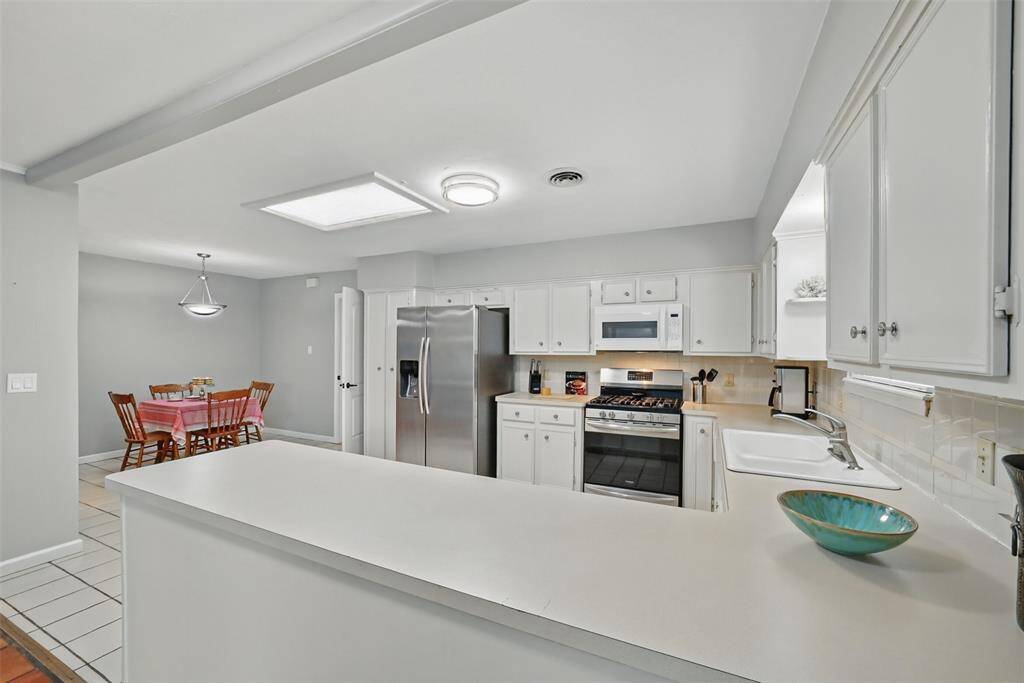 VIEWS OF THE KITCHEN AND SPACIOUS BREAKFAST AREA. PLENTY OF COUNTER SPACE FOR BUFFET STYLE ENTERTAINING.