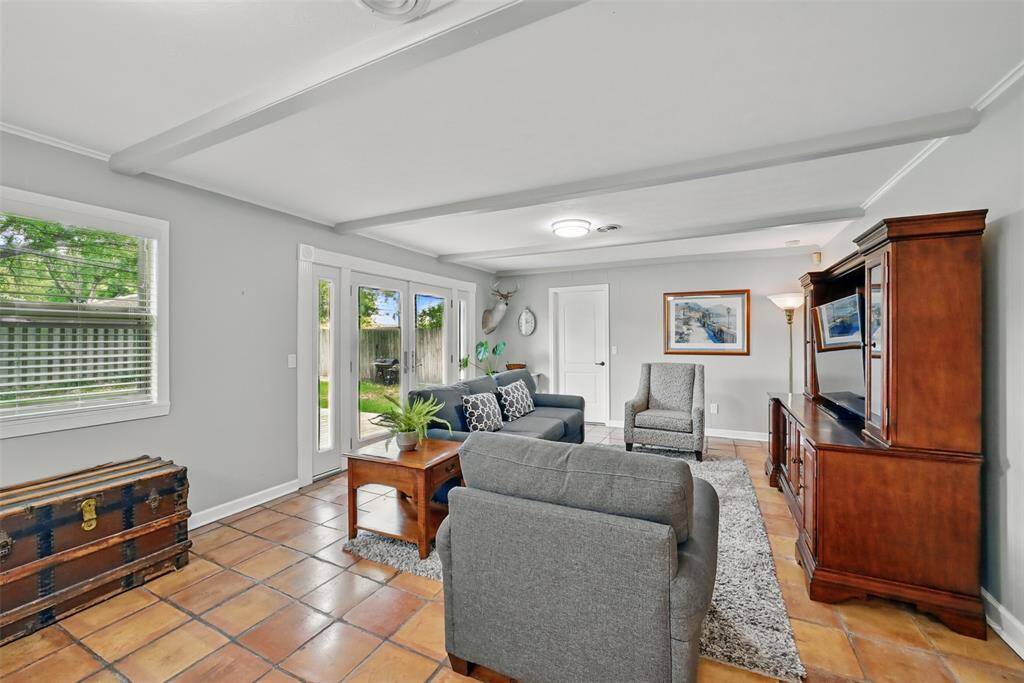 THE FAMILY ROOM IS BOTH ELEGANT AND COMFORTABLE WITH SALTILLO TILE FLOORING AND LARGE FRENCH DOORS OPENING ONTO THE PATIO.