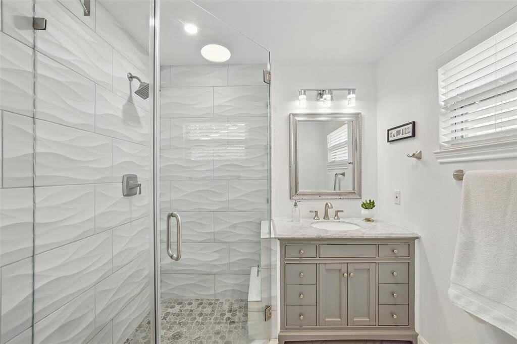 THE LUXURIOUS EN-SUITE BATHROOM WAS REMODELED IN 2022. GORGEOUS CUSTOM CABINETS, QUARTZ COUNTER AND CHIC LIGHTING HAVE BEEN INSTALLED. THE WALK-IN SHOWER IS HUGE WITH FLOOR TO CEILING TILE.
