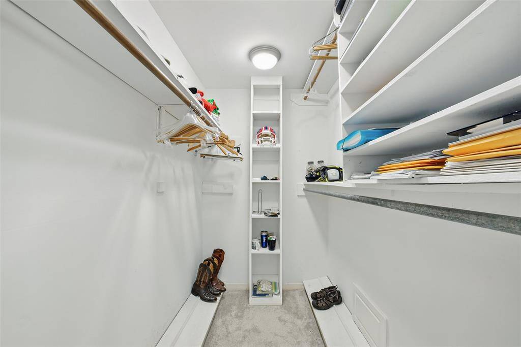 WALK-IN CLOSET WITH AMPLE RAILS AND SHELVES FOR EASY ORGANIZING.