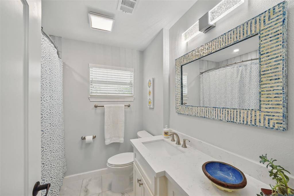 REMODELED SECONDARY BATHROOM (2022) WITH QUARTZ COUNTER AND CHIC LIGHTING.