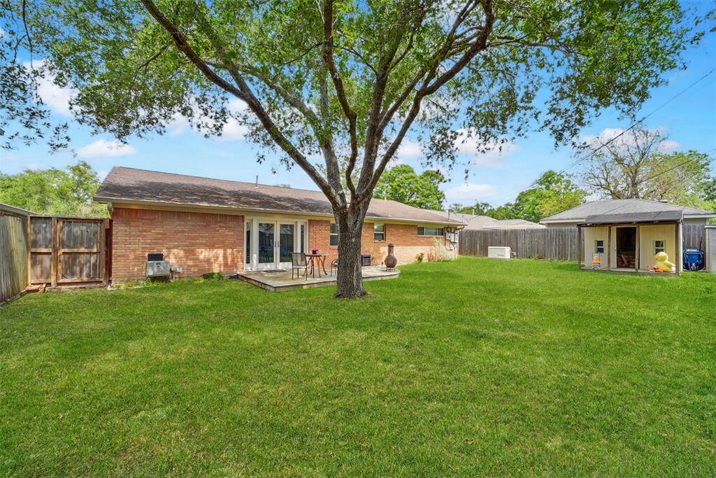 THE MATURE TREE KEEPS THE BACKYARD SHADED.