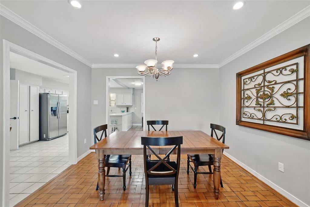 ANOTHER VIEW OF THE FORMAL DINING AREA WITH CROWN MOLDING AND OPENNING THROUGH TO THE KITCHEN.