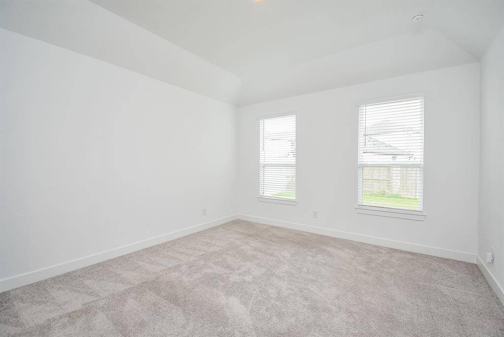 Spacious primary bedroom with abundant natural light from large windows, offering a serene retreat.
