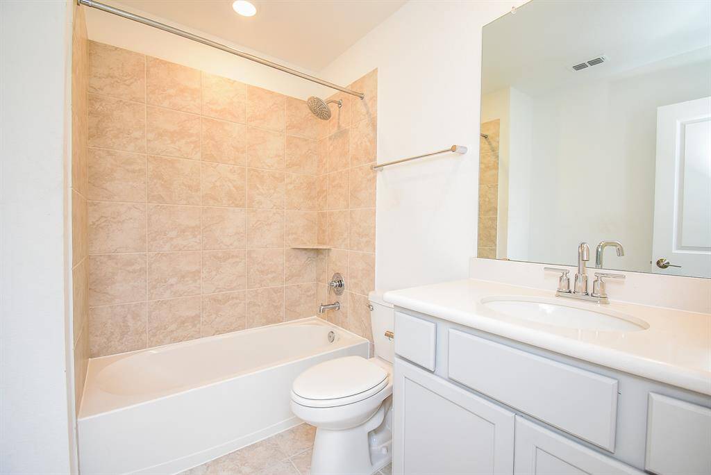 Inviting secondary bathroom with elegant tilework and modern fixtures.