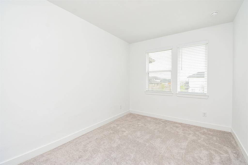Bright and cozy secondary bedroom with plush carpet and ample natural light. Perfect for guests or a home office.