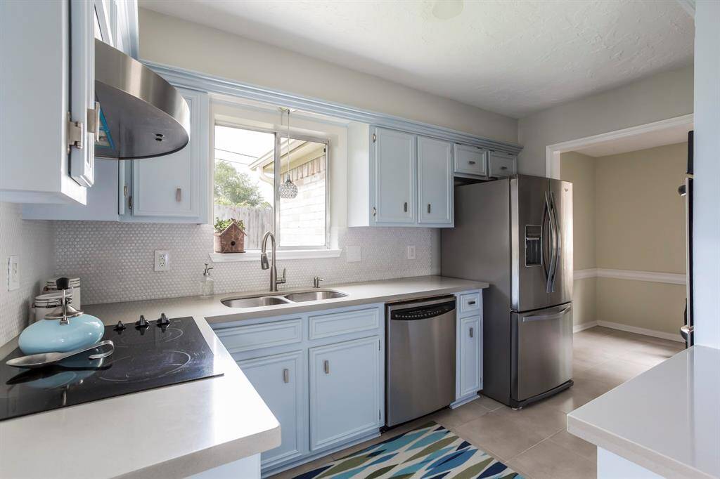 This light and cheerful kitchen offers ample cabinetry, sleek stainless steel appliances, quartz countertops, and stylish tile backsplash. A large window over the sink brings in natural light and offers a backyard view, while the thoughtful layout ensures everything is within easy reach for everyday cooking or weekend baking. As an added bonus, the refrigerator stays!