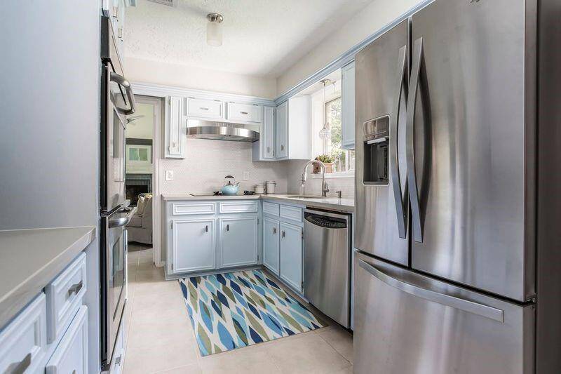 This charming kitchen is as functional as it is inviting, with double built-in ovens, an electric cooktop, and an automatic dishwasher to make meal prep and clean up a breeze. Painted cabinetry and designer tile backsplash add personality, while the layout flows easily to the formal dining room and a separate breakfast area, perfect for everything from weekday breakfasts to holiday dinners.