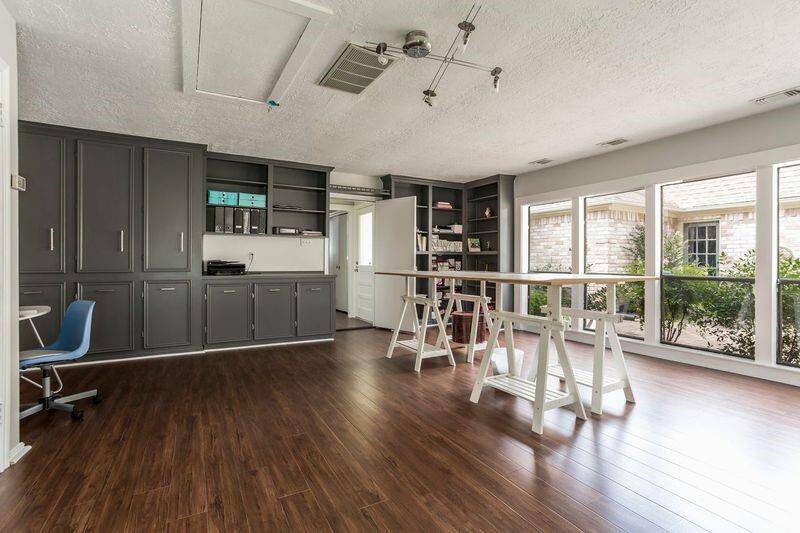 Storage meets style in this oversized game room, featuring an entire wall of built-in cabinetry and open shelving to keep everything neatly organized. Whether you're storing games, books, art supplies, or tech gear, there's a place for it all—making this a truly versatile space for work or play.