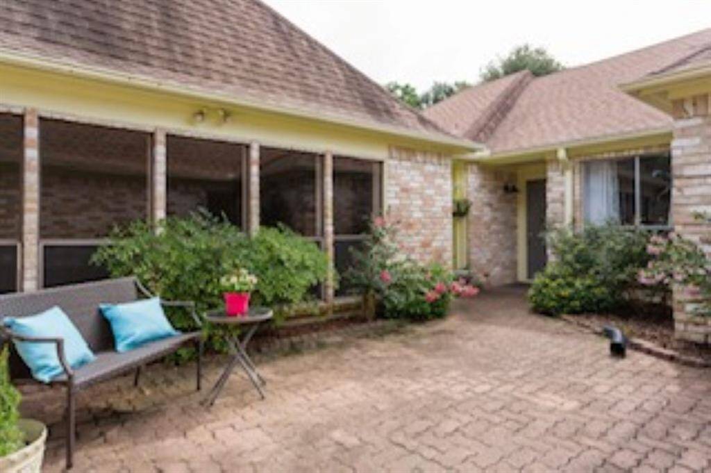 Step through the gate into your own private courtyard entry, where brick pavers, blooming garden beds, and space for your favorite patio set create a warm and welcoming first impression.