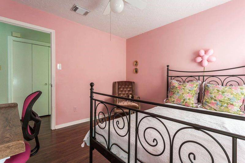 An alternate view of this charming guest bedroom shows durable and beautiful laminate flooring and plenty of space for personal touches.