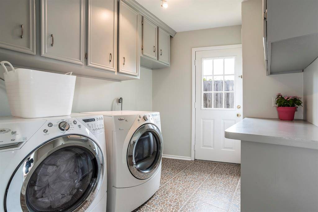 This tidy laundry room makes chores feel a little easier, with plenty of upper and lower cabinetry for storage, a folding counter, and direct access to the backyard. There’s even space for a freezer or second refrigerator, making it as practical as it is stylish with durable tile flooring and neutral finishes throughout. The washer and dryer are included while the small beverage refrigerator is excluded.