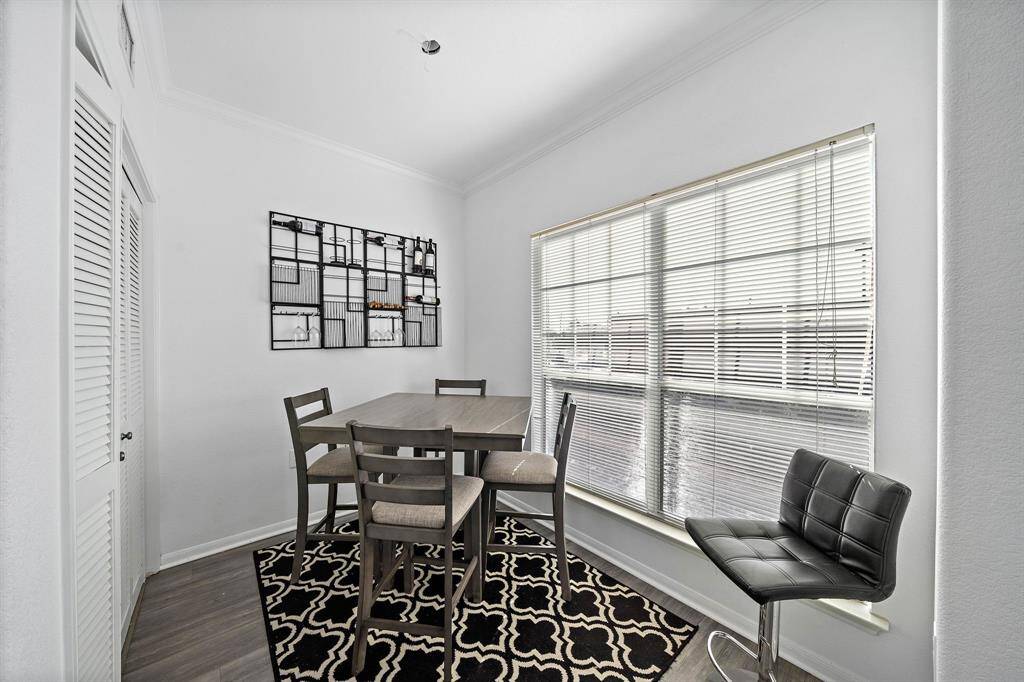 This photo shows a bright dining area and large windows with blinds providing ample natural light. The space feels open and inviting.