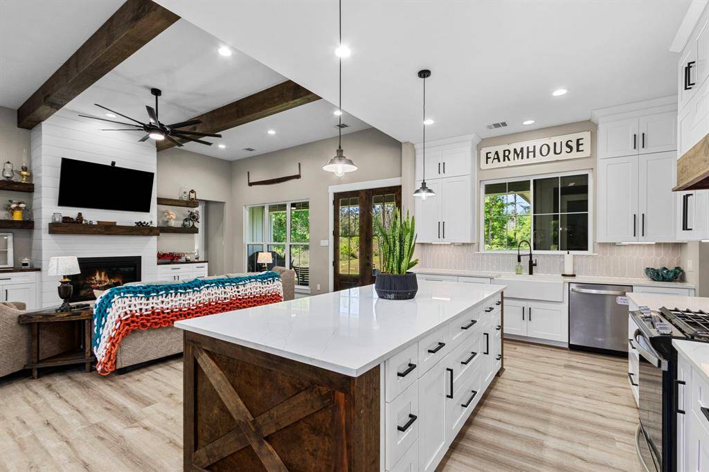 Beautiful bright, white, and open kitchen/living concept. Oversized Island with tons of storage, outlets under the bar, hidden away. Custom woodwork on the sides that add texture and luxury.