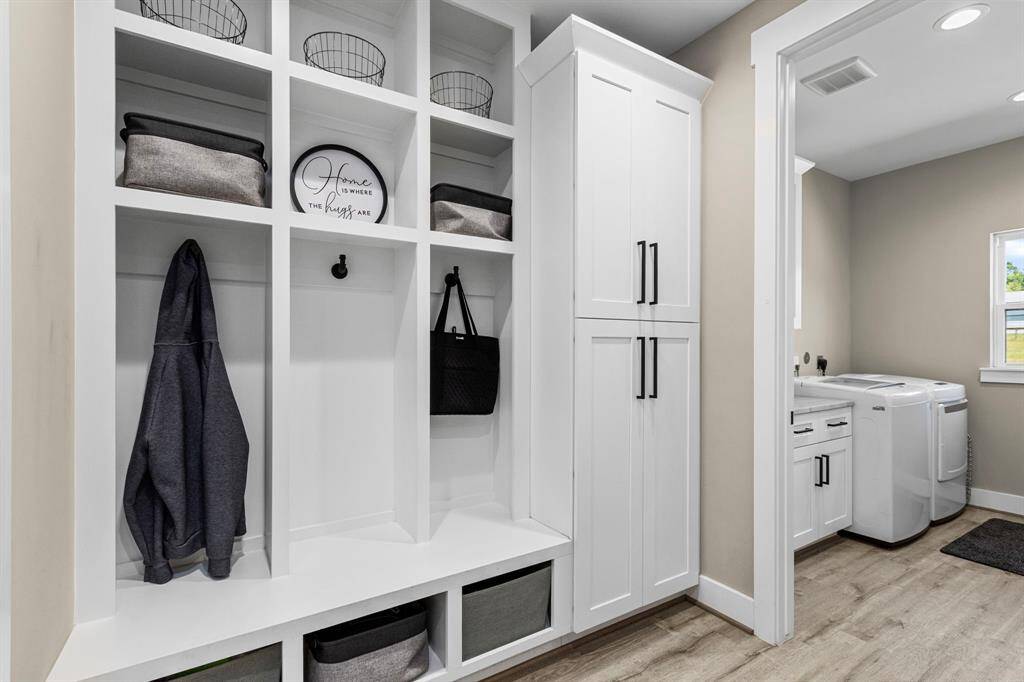 Large mudroom area with built-in cabinets equipped with electrical outlets to house cleaning electronics.