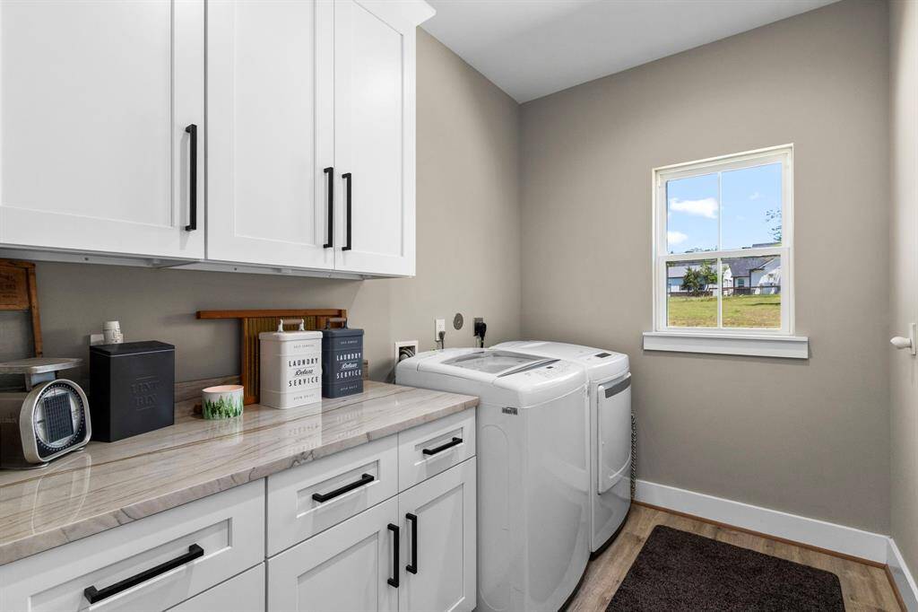 Perfectly designed laundry space with storage, counter top working area, as well as electric and gas connections.