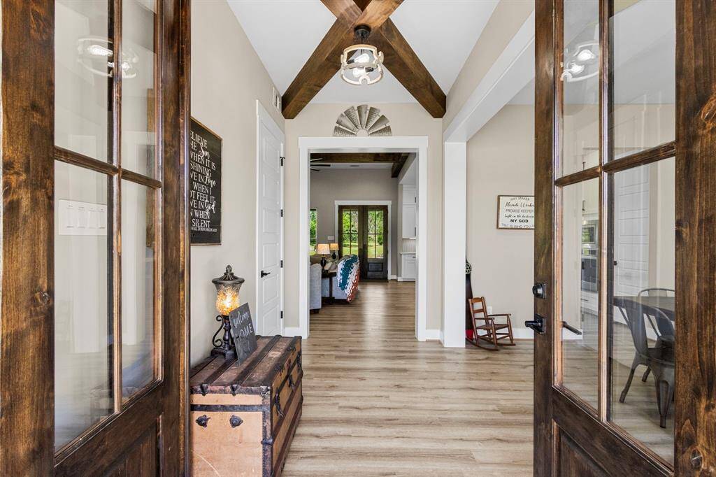 Large open entry way, with a coat closet. The beams and light fixtures add so much appeal to your entry way.