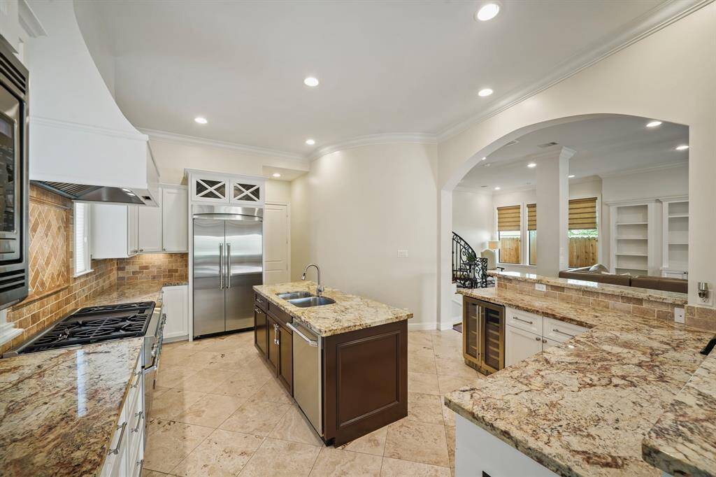 Providing additional counter & prep space is an accented wood-stained island complete with a stainless steel under-mount sink and pull-out trash bin.
