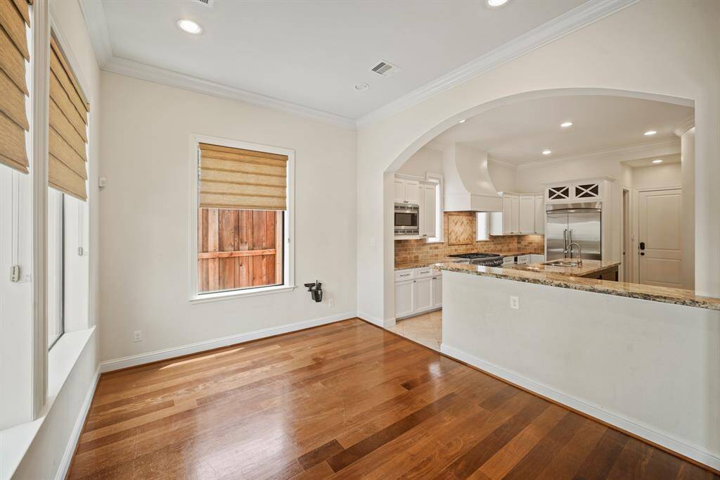 Located off the kitchen, this bright & cheery breakfast room includes crown moulding, recessed lighting & windows with Roman shades.