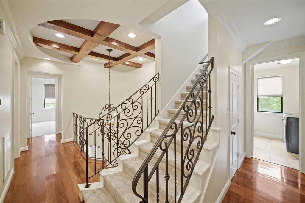 A view of the second floor corridor with the wrought iron staircase leading to the third floor game room.