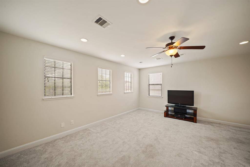Nestled on the third level of the home is a spacious game room with recessed lighting, windows with blinds and an entertainment center with a flat screen TV. Included is a full private bath and an 11' x 11' climate controlled storage room.