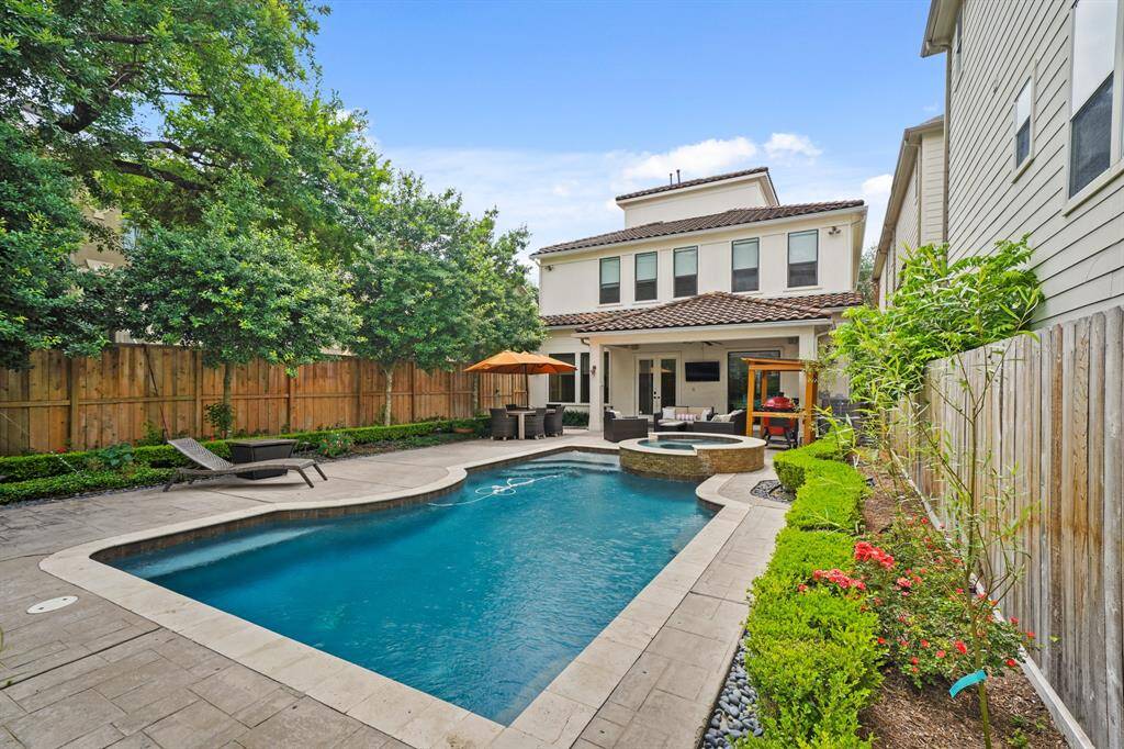 Offering multiple entertaining venues, this backyard also includes a covered patio as shown in the background. Inluded is a "catch-a-kid" pool system for safety.