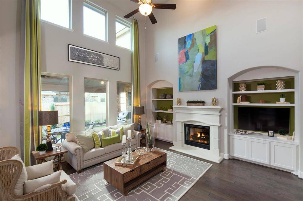 Soaring two-story ceilings and high-set transom windows flood this family room with natural light.